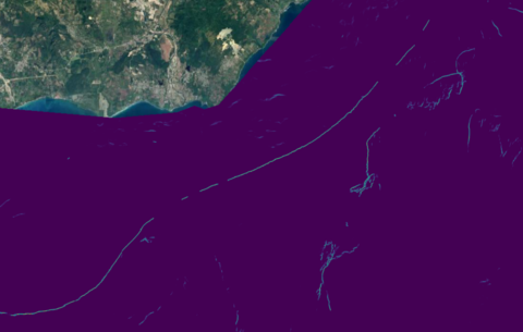 Dominican_republic_detection.png: An image showing Plastic-i’s debris detection AI computer vision model applied to a scene near the Dominican Republic, with a large debris accumulation (~50km long) shown in the right of the image. The image was captured in 2022.